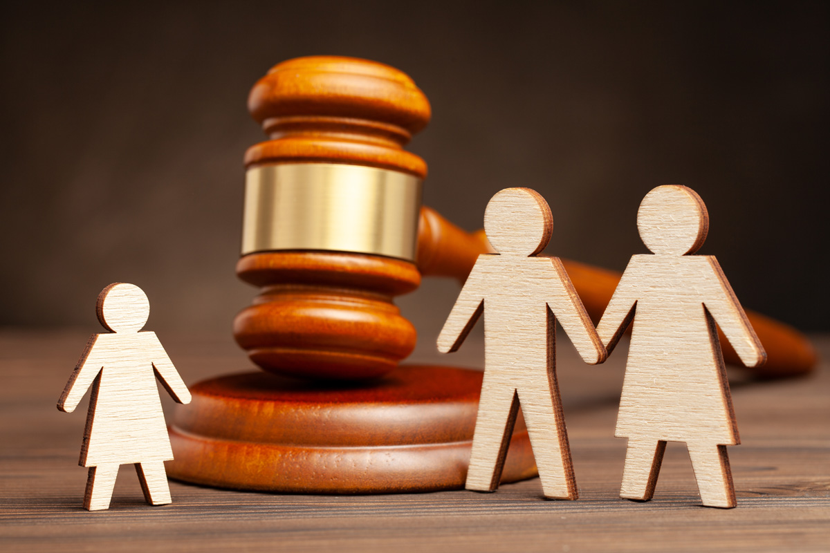 A gavel next to wooden cutouts of two parents and a child in El Paso.